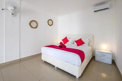 a bedroom with a white bed with red pillows at Luxury minimalist villa White Angel in Seminyak, sleeps 21 people in total in Seminyak