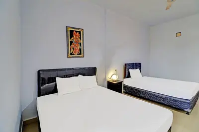 two beds in a room with white walls at Capital O 92094 Hotel Kertha in Pesanggaran