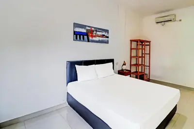 a bedroom with a large white bed in a room at Capital O 92094 Hotel Kertha in Pesanggaran