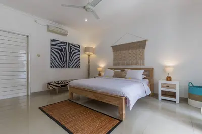 a bedroom with a large white bed and a table at Central & Charming 3bedr with private pool in Seminyak