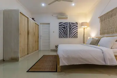 a bedroom with a large bed and a painting on the wall at Central & Charming 3bedr with private pool in Seminyak