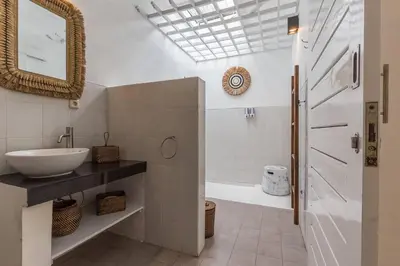 a bathroom with a sink and a tub and a mirror at Central & Charming 3bedr with private pool in Seminyak