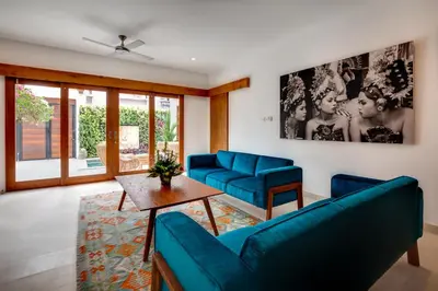 a living room with blue couches and a table at Malinda Villa Seminyak in Seminyak