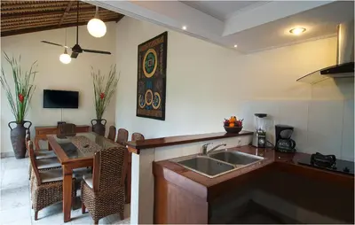 a kitchen with a sink and a table and a dining room at 6BR Villa Sensel - Minggu Villas Seminyak in Seminyak