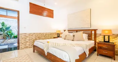 a bedroom with a bed and a window at Taman Hijau Villa by iBali Management in Kerobokan