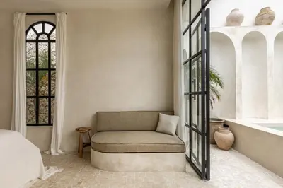 a bedroom with a couch and a tub and a window at Private Pool Villa Bocami Suites- 2 by OriVista in Kerobokan