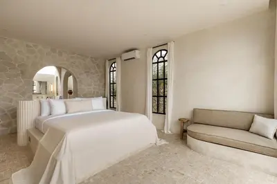 a bedroom with a large white bed and a couch at Private Pool Villa Bocami Suites- 2 by OriVista in Kerobokan