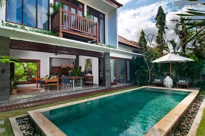 a house with a swimming pool in front of a house at 8BR Villa Mason - Minggu Villas in Seminyak