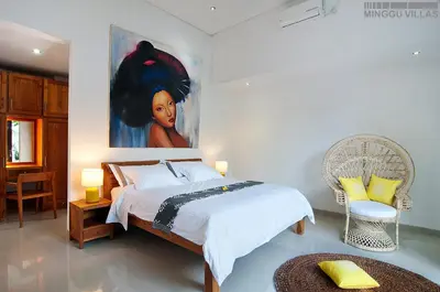 a bedroom with a bed with a painting on the wall at 8BR Villa Mason - Minggu Villas in Seminyak