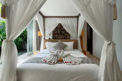 a bedroom with a canopy bed with white curtains at Villa Deh Simba at Seminyak Aramanis in Seminyak
