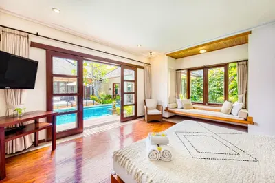 a bedroom with a bed and a television and a pool at Villa Jalamati in Seminyak