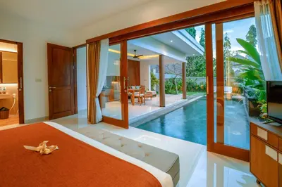 a bedroom with a pool and a bed and a tv at Kahayana Seminyak Villa in Seminyak