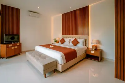 a bedroom with a large bed and a television at Kahayana Seminyak Villa in Seminyak