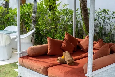 a teddy bear sitting on a couch with pillows at Villa Kalamansi Seminyak in Seminyak