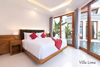 a bedroom with a white bed with red pillows at Villa Mia Seminyak - Boutique Villas - II in Seminyak