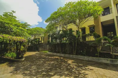 a walkway in front of a building with trees at Abisha Villa Jimbaran in Jimbaran
