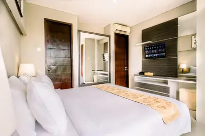 a bedroom with a white bed and a large window at Abisha Villa Jimbaran in Jimbaran