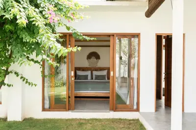 a house with a glass door with a bed in it at Villa Folie by Alfred in Bali in Seminyak