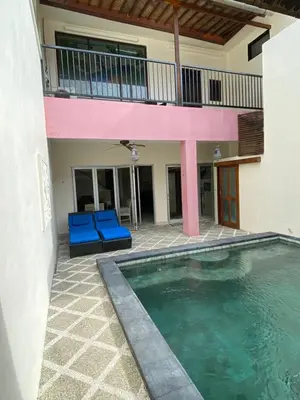 a house with a swimming pool and blue chairs at 5 Bedroom Getaway Villa - Kuta Regency B3 in Kuta