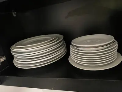 a stack of white plates sitting on a shelf at 5 Bedroom Getaway Villa - Kuta Regency B3 in Kuta