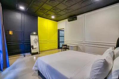 a bedroom with a white bed and a yellow wall at Villa Canberra - Seminyak in Seminyak