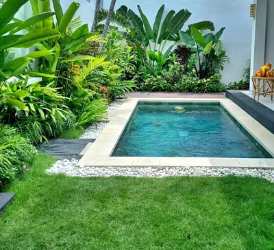 a swimming pool in the middle of a garden at Alam Jepun Villa in Legian