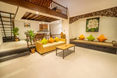 a living room with yellow and green pillows at Alam Jepun Villa in Legian