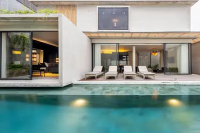 a house with a swimming pool in front of a house at INSPIRA Seminyak in Seminyak