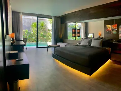 a bedroom with a large bed and a living room at INSPIRA Seminyak in Seminyak