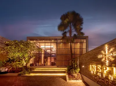 a building with a palm tree in front of it at INSPIRA Seminyak in Seminyak