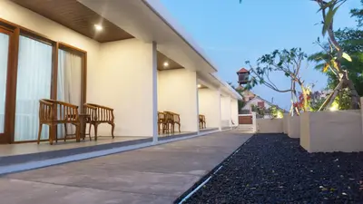 a porch of a house with chairs and a table at Kedin's Inn in Denpasar