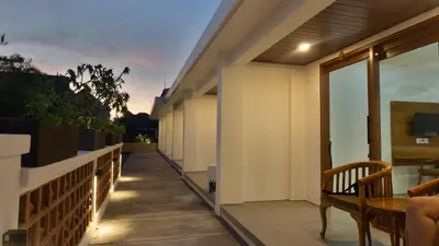 a balcony of a house with a table and chairs at Kedin's Inn in Denpasar