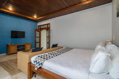 a bedroom with a large bed and a television at Villa Kori Bali Kubu, 9 people maximum, close to Seminyak Beach in Seminyak