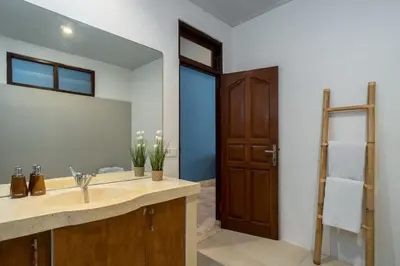 a bathroom with a sink and a large mirror at Villa Kori Bali Kubu, 9 people maximum, close to Seminyak Beach in Seminyak