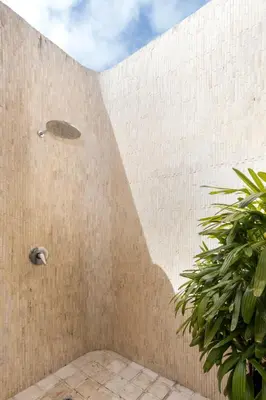 a shower in a brick wall with a plant at Villa Suvitha by Villa Finder in Seminyak