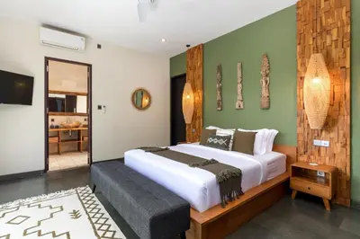 a bedroom with a large white bed and green walls at Villa Suvitha by Villa Finder in Seminyak