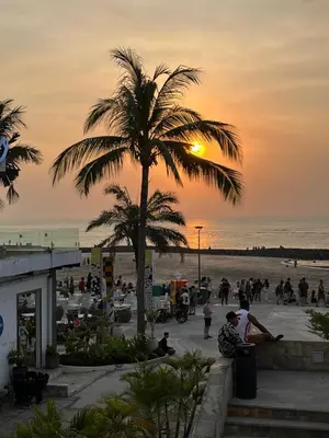 a palm tree on the beach at sunset at Largest Villa in Kuta Royal C1 - Turquoise Villa in Kuta