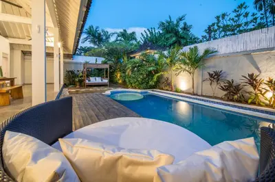 a swimming pool with a table and chairs next to a house at Villa Seminyak - 2bdr private big pool villa in Seminyak