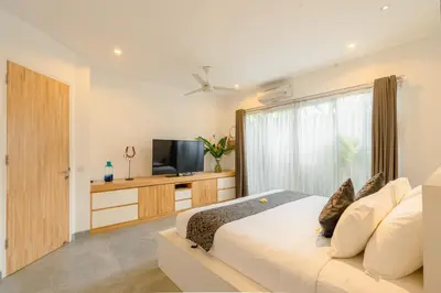 a bedroom with a large bed and a television at Villa Becca Seminyak by Best Deals Asia Hospitality in Seminyak