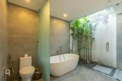 a bathroom with a bath tub and a toilet at Villa Becca Seminyak by Best Deals Asia Hospitality in Seminyak