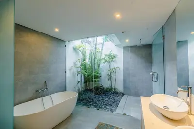 a bathroom with a tub and a toilet and a sink at Villa Becca Seminyak by Best Deals Asia Hospitality in Seminyak