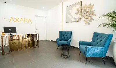 a waiting room with two blue chairs and a tv at The Axara Bali Managed by ARM Hospitality in Nusa Dua