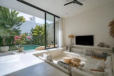 a living room with a white couch and a large window at Casa Noema in Kerobokan