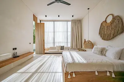 a bedroom with a bed and a living room at Casa Noema in Kerobokan