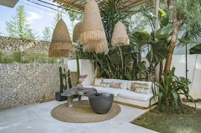 a patio with a white couch and a table at Casa Noema in Kerobokan