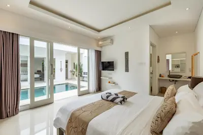 a bedroom with a large bed and a swimming pool at Fresh and Stylish 3bd Villa in Seminyak with Private Pool in Seminyak