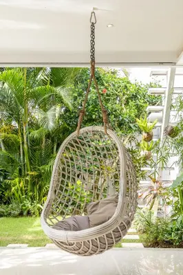 a wicker swing chair hanging from a porch at Fresh and Stylish 3bd Villa in Seminyak with Private Pool in Seminyak