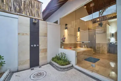 a bathroom with a glass shower and a sink at Villa Bulan Batubelig in Canggu
