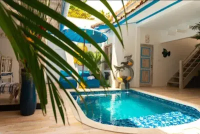 a swimming pool in a living room with a plant at Shray Villa. Legian in Legian
