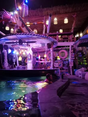 a swimming pool in a room with a bar at Shray Villa. Legian in Legian